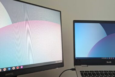 ID: a photo of a monitor screen and laptop, both showing a stock wallpaper image.