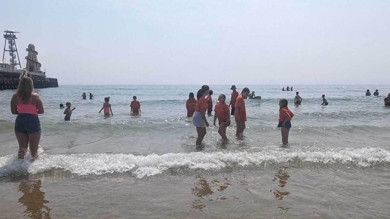 ID: Branch Up volunteers and young people play in the sea